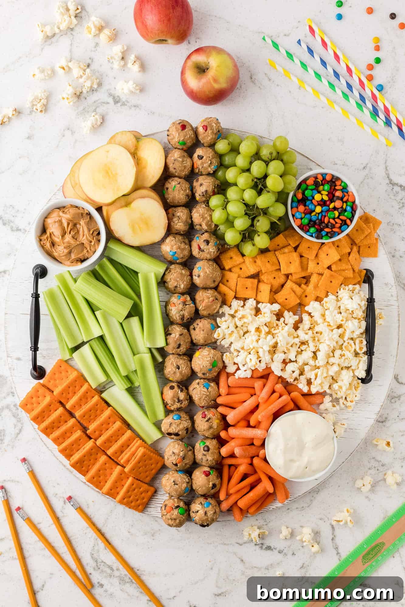 Vibrant after-school snack board featuring crackers, fresh fruits, and various healthy snacks.