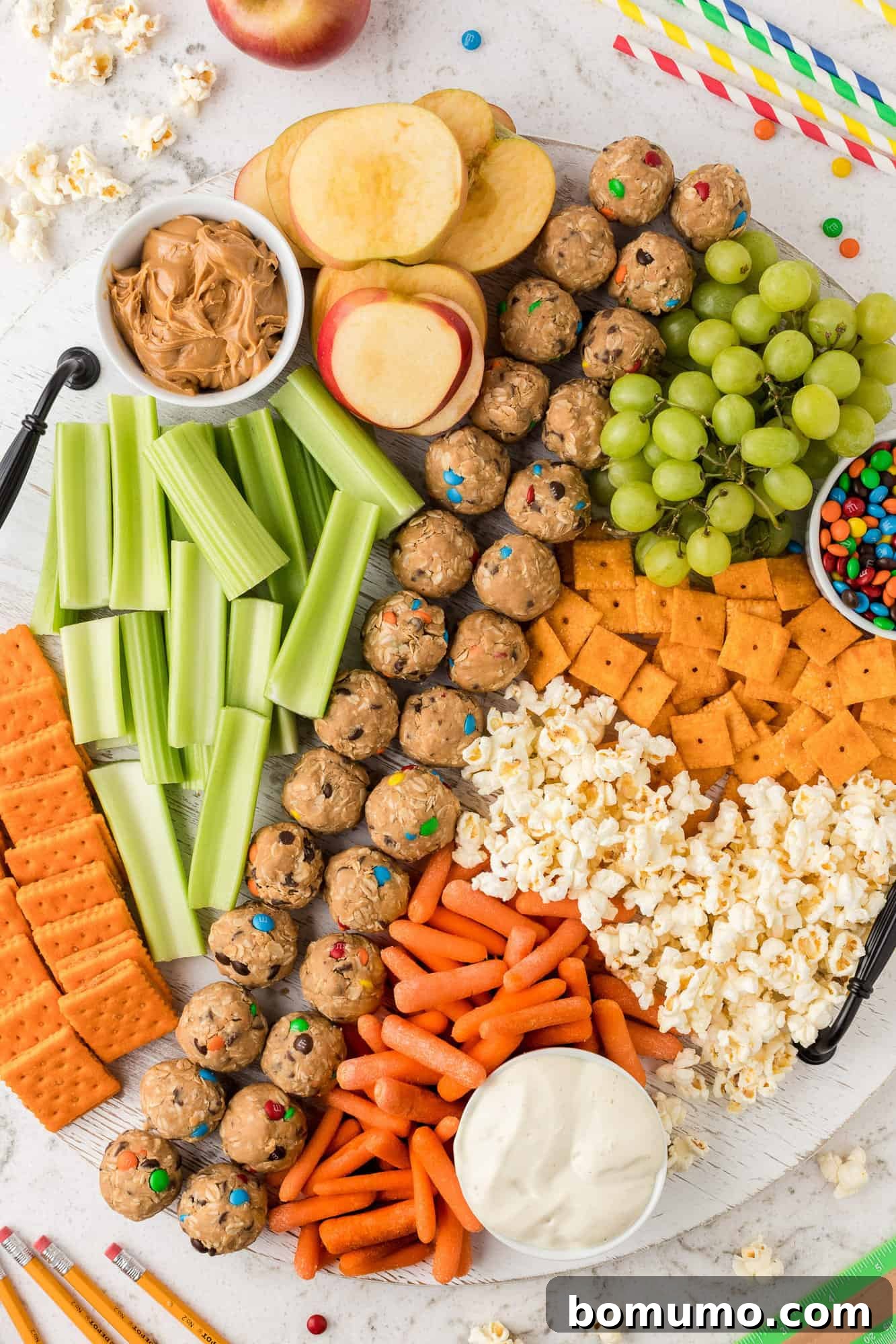 An inviting snack board overflowing with various fruits, crackers, and other delicious bites.