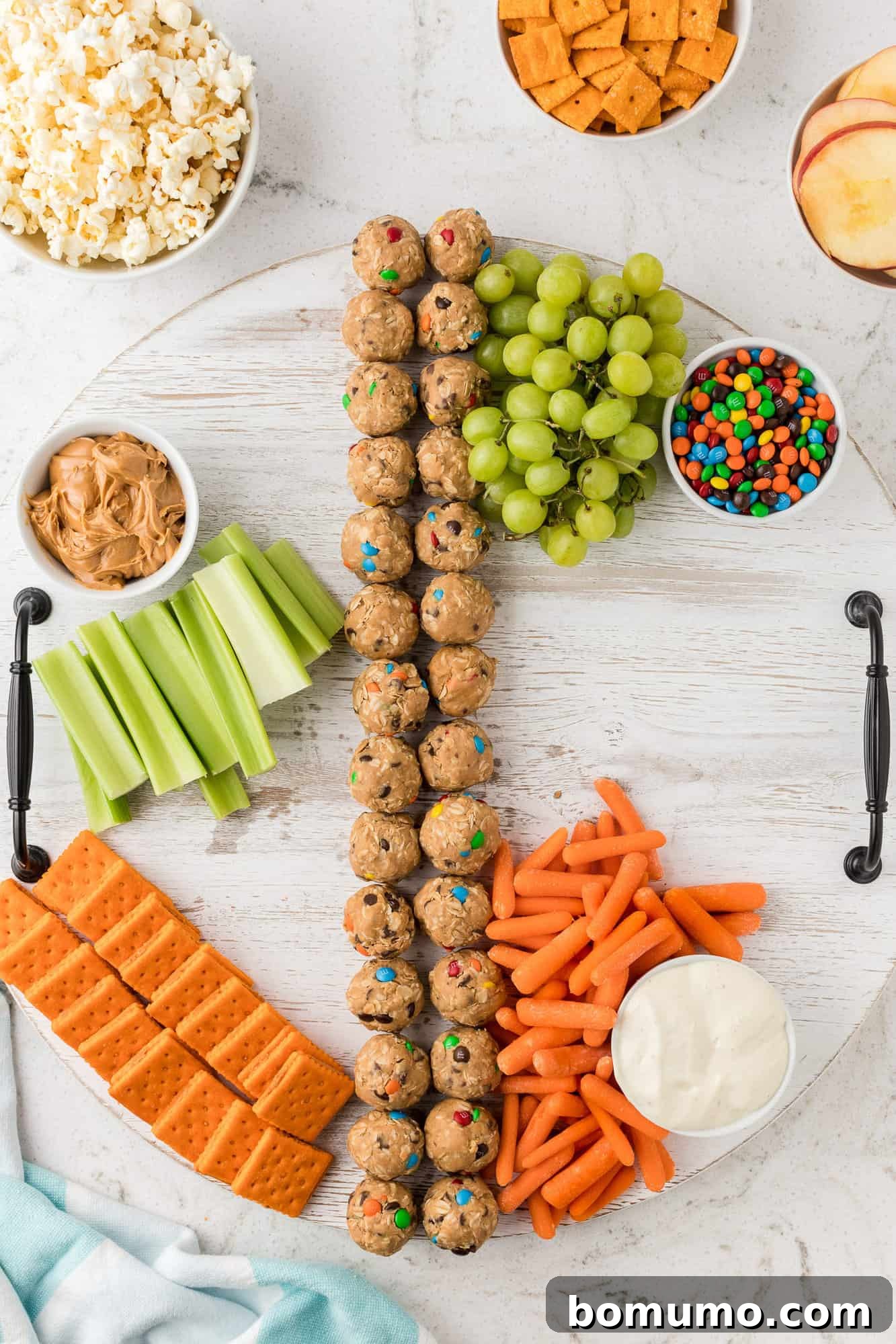 A snack board being assembled, with various colorful ingredients thoughtfully arranged.