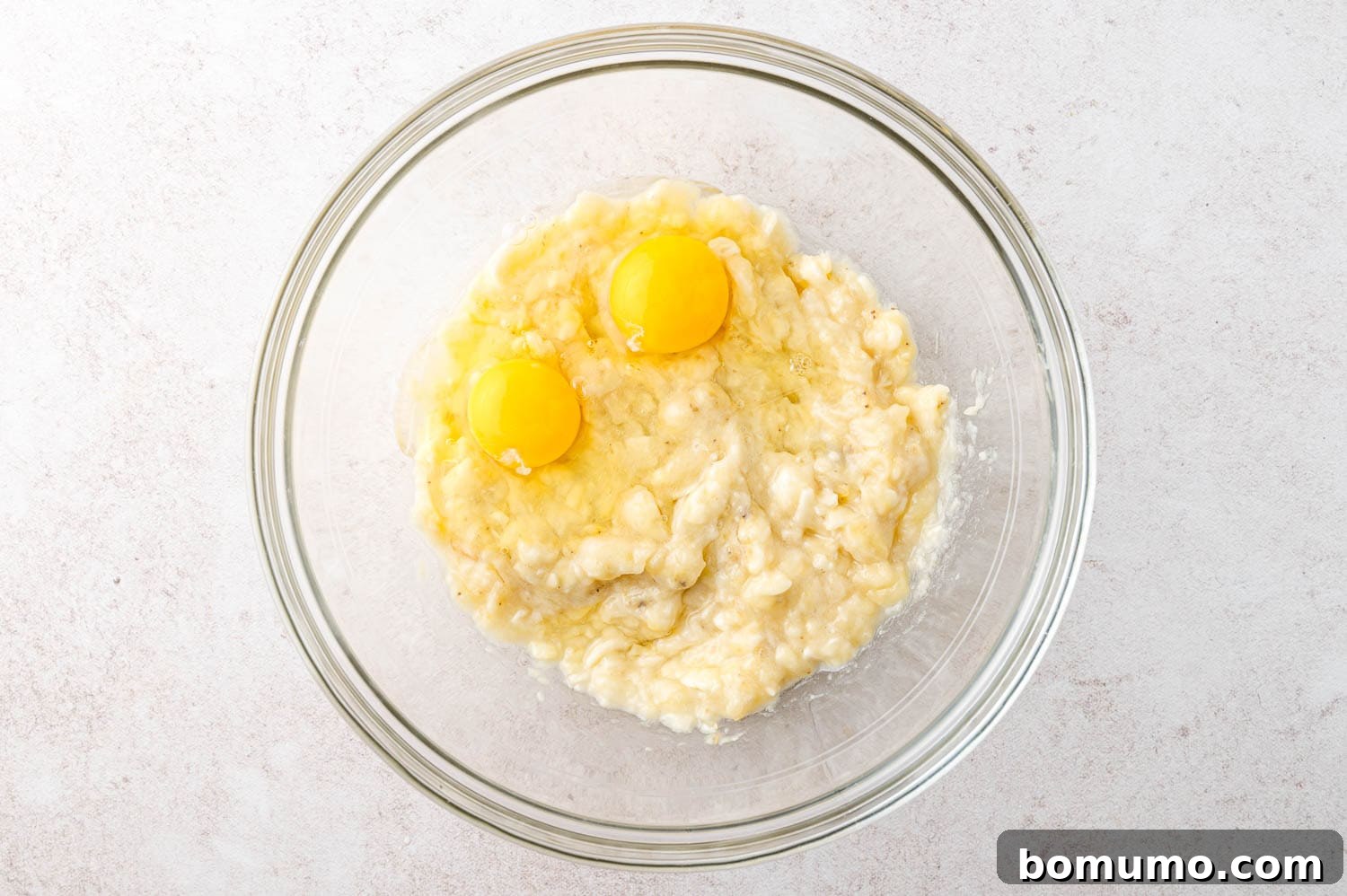 Eggs added to mashed bananas.
