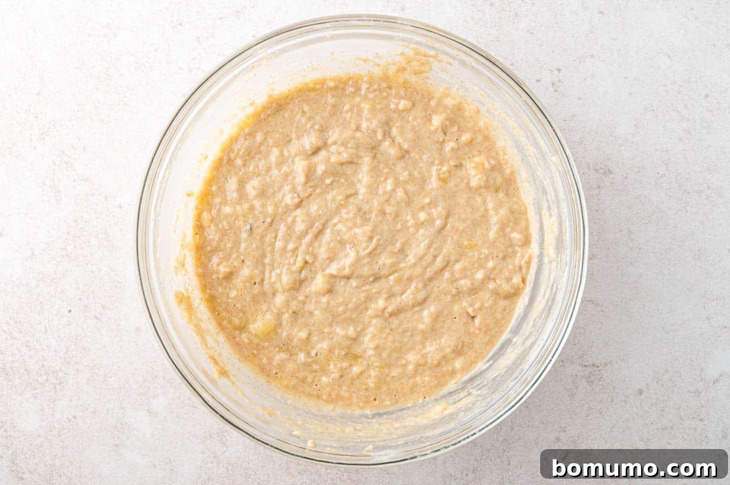 Muffin batter in a large glass mixing bowl.