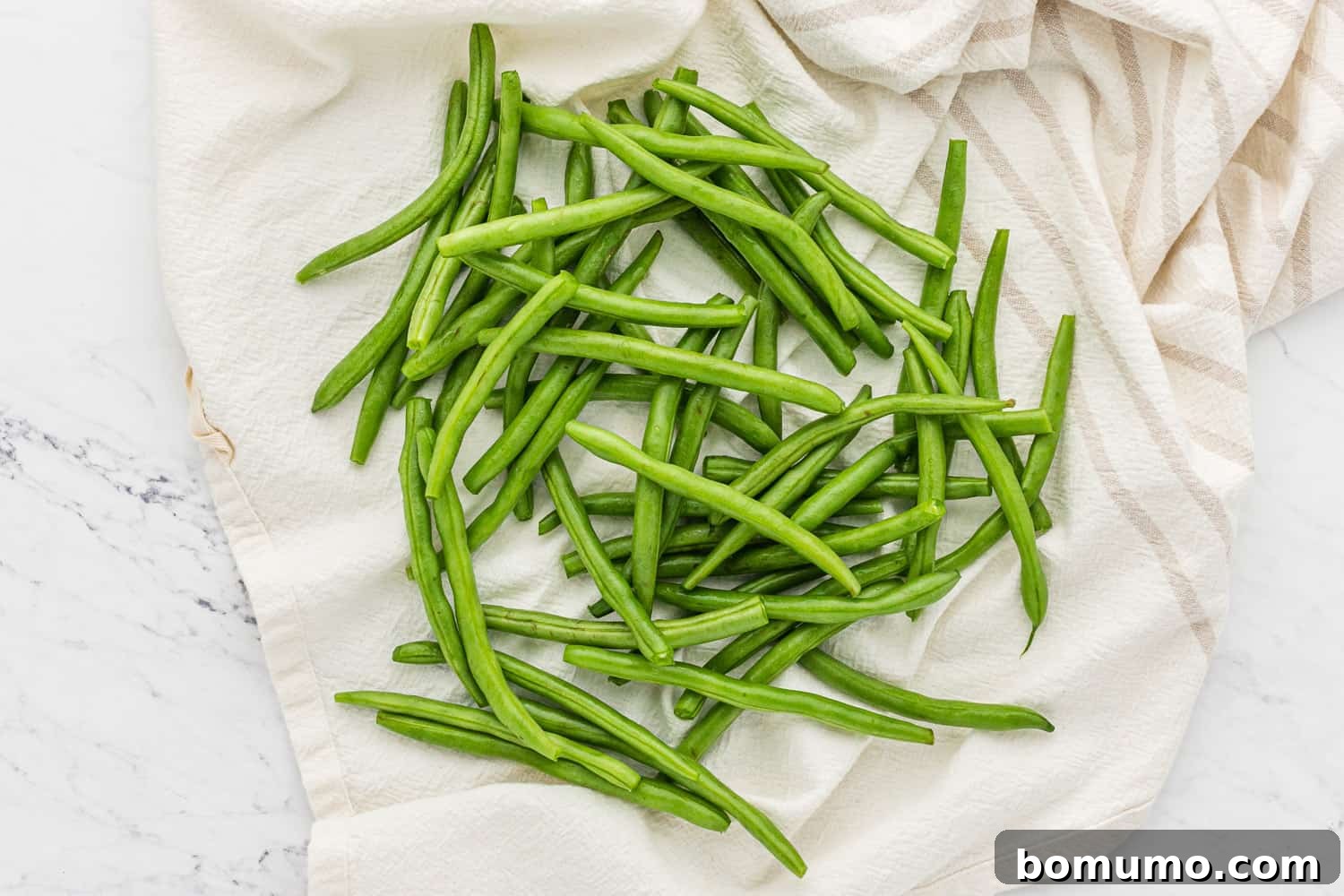 Fresh green beans, expertly trimmed and cleaned, ready for seasoning.