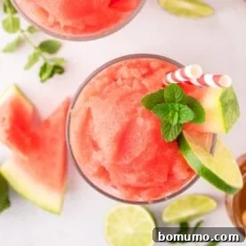 Overhead view of watermelon slushie garnished with lime and mint.
