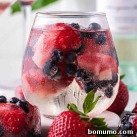 White wine spritzer with berry ice cubes.