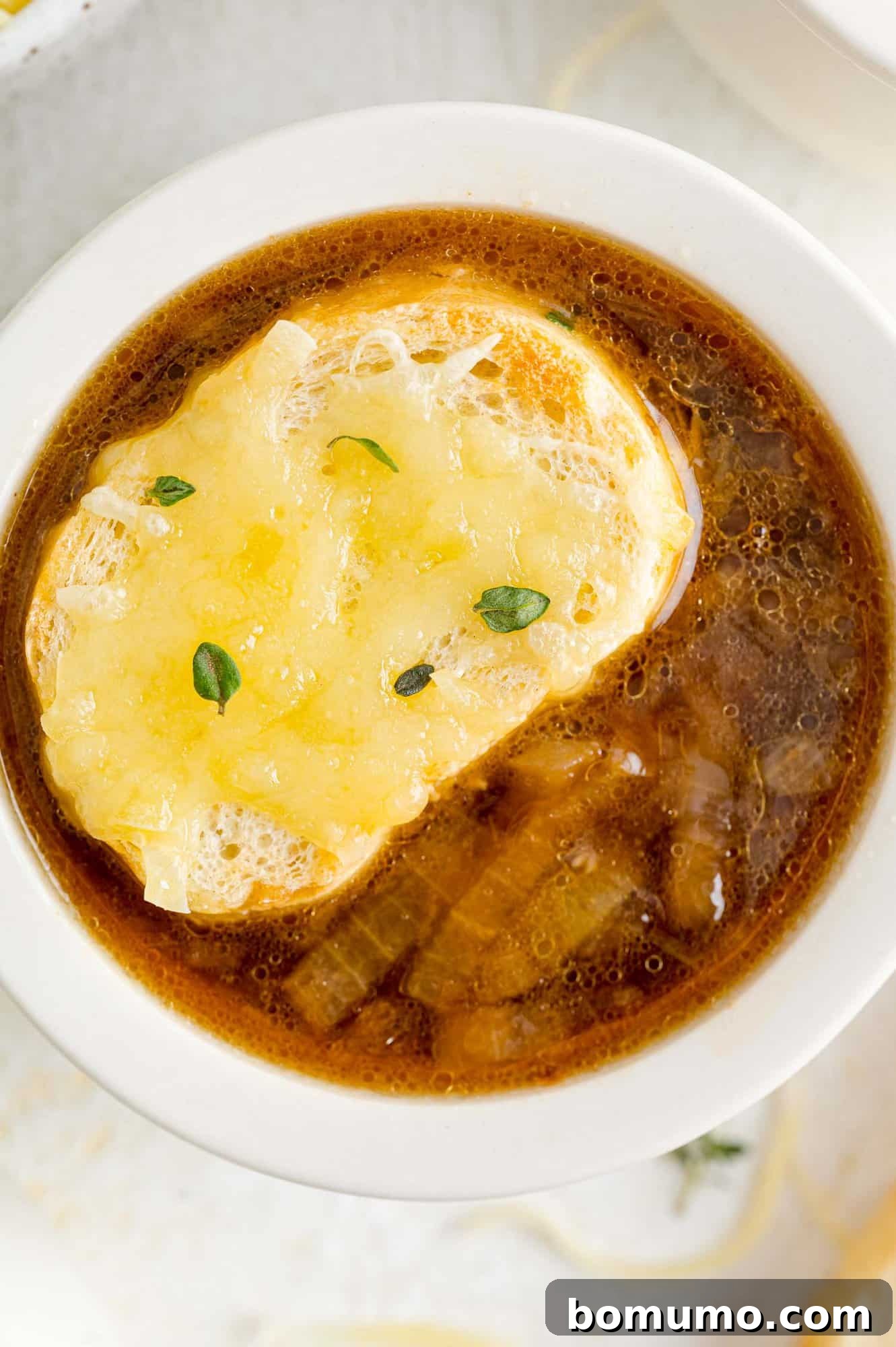 French onion soup topped with cheese-covered bread, ready to be served.