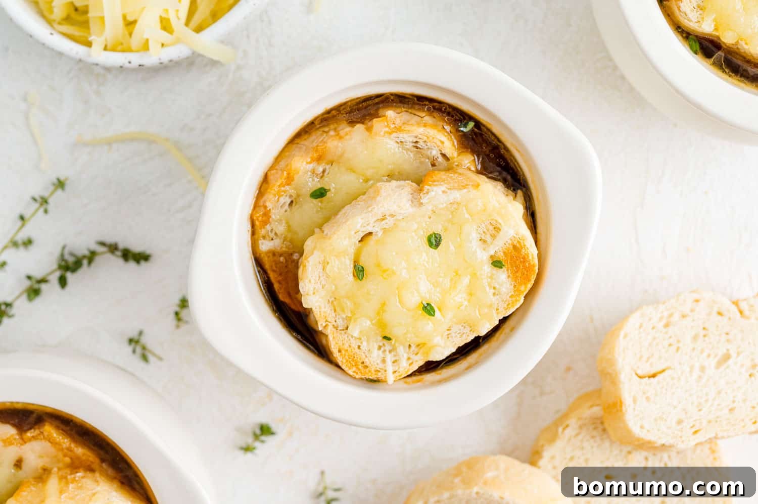 Finished French onion soup in an oven-safe crock with melted Gruyère cheese and golden bread.