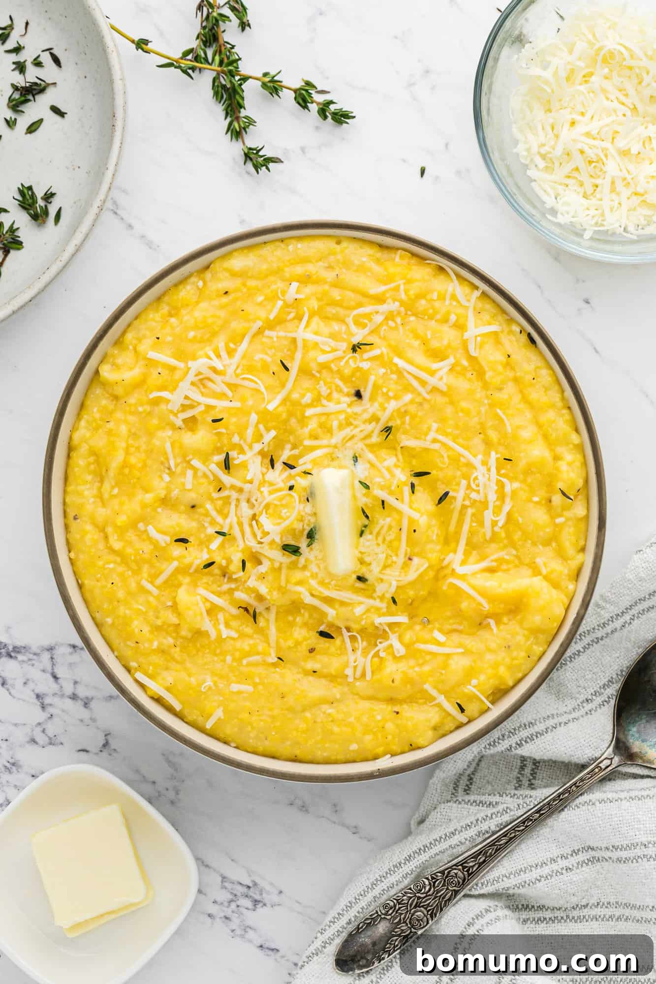 Instant pot polenta garnished with butter and fresh thyme, showcasing its creamy texture.