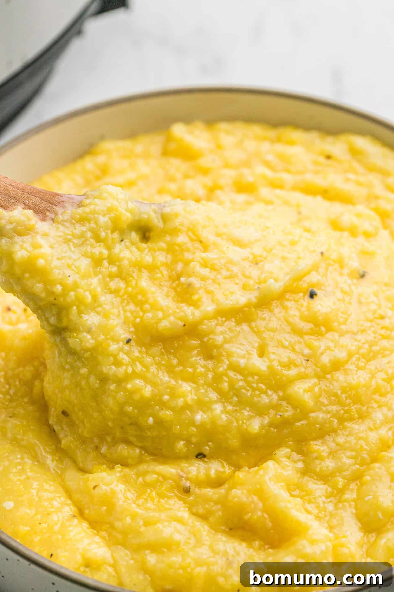 Close up of creamy polenta, showing its inviting and smooth texture, ready to be enjoyed.