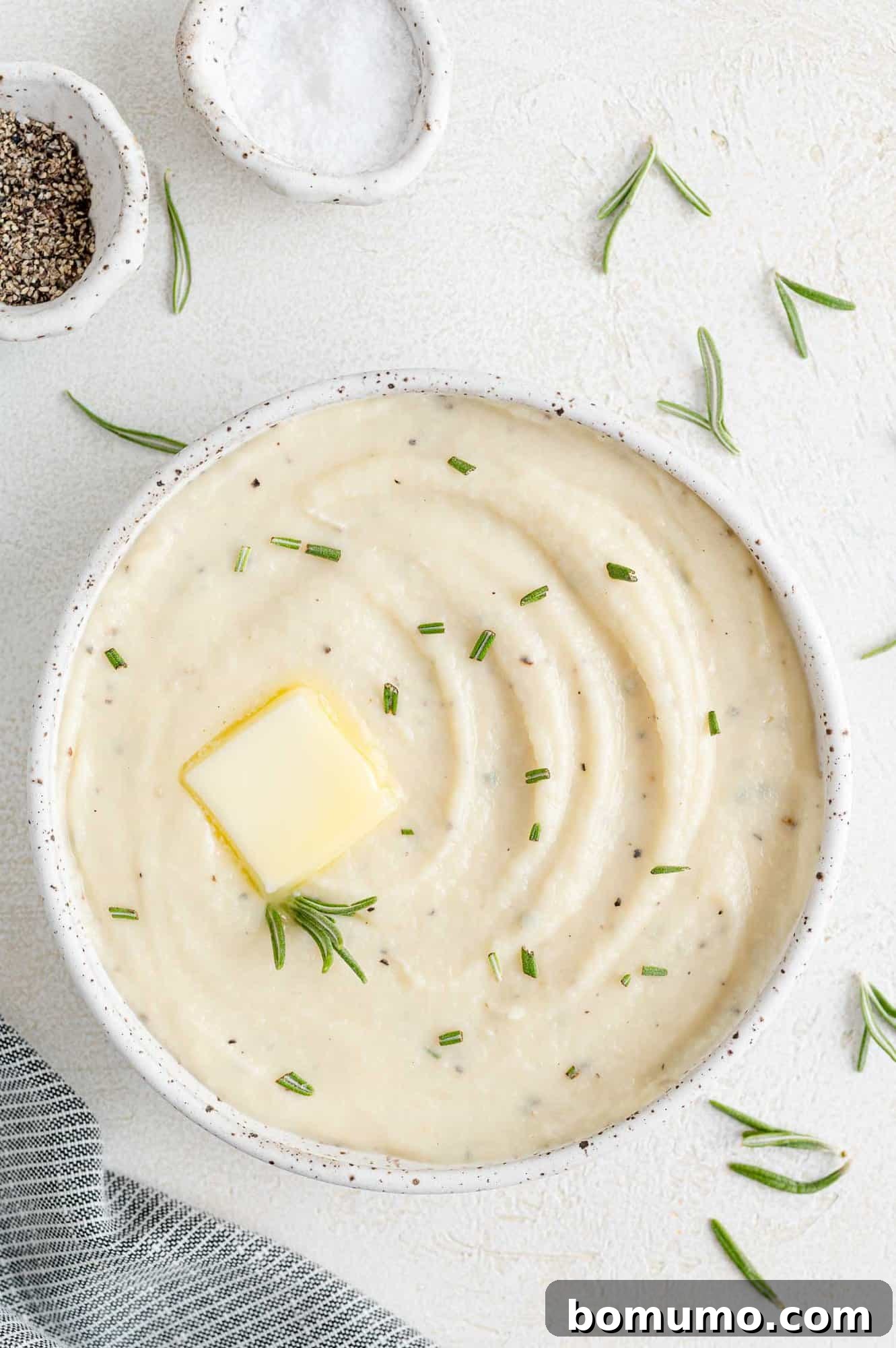 Silken Parsnip Puree 2 Creamy parsnip puree in a white bowl, garnished with fresh herbs.