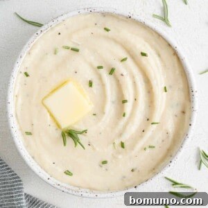 Creamy white parsnip puree garnished with fresh rosemary.