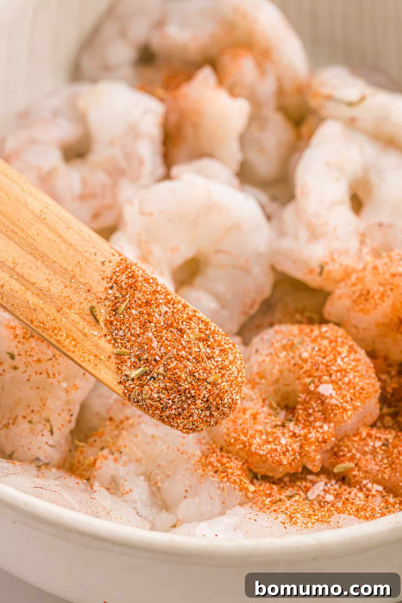 Cajun Spice Blend 9 Cajun seasoning being added to shrimp.