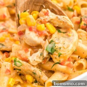 Cajun chicken pasta with a wooden spoon, showcasing its creamy texture.