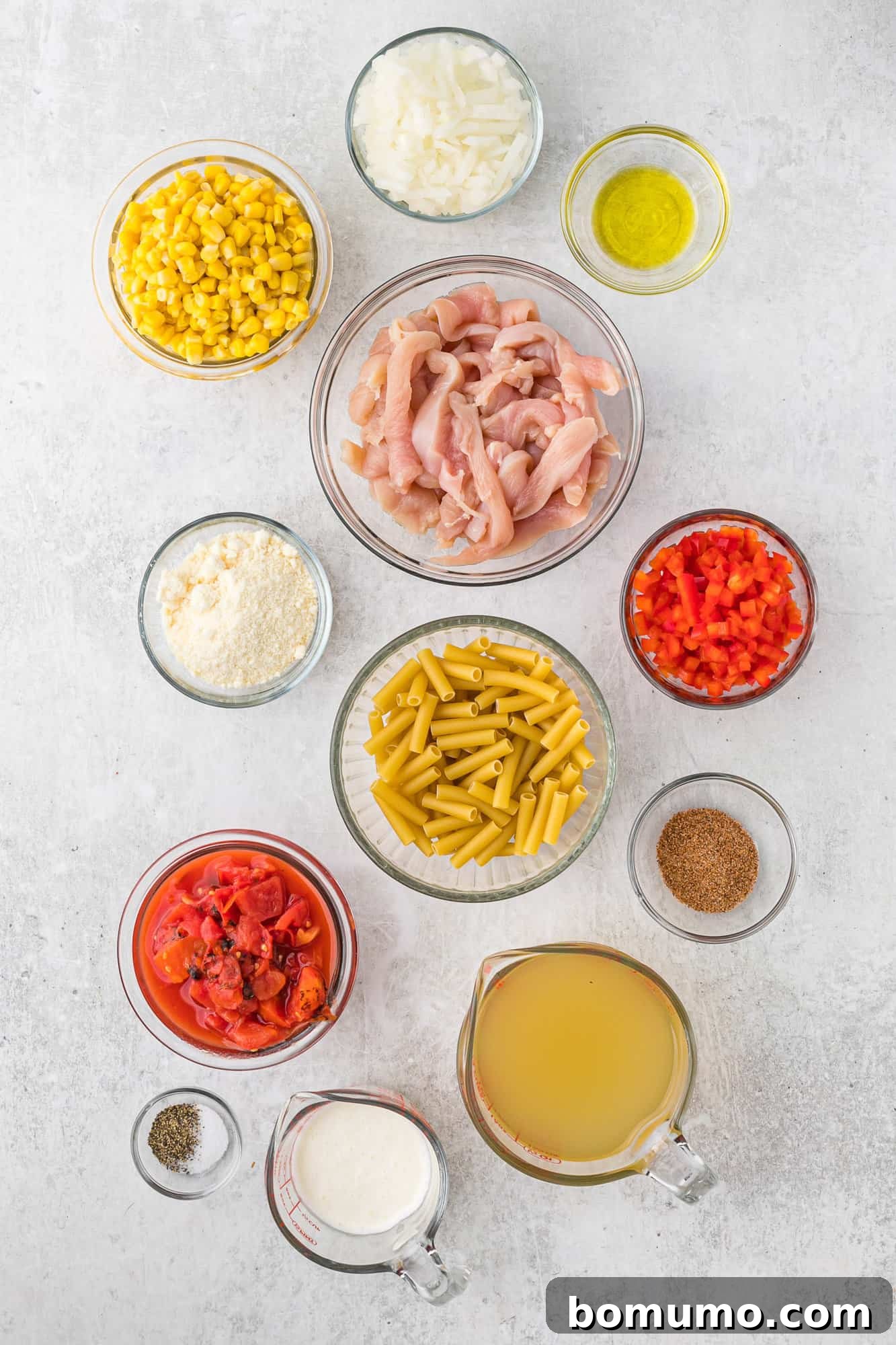 A collection of fresh ingredients laid out for making Cajun chicken pasta.