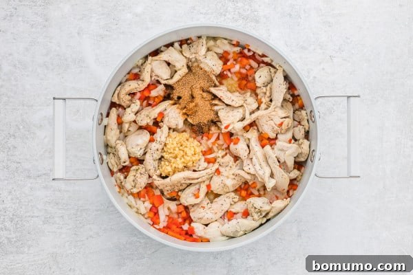 Minced garlic and Cajun seasoning added to the pan with chicken and vegetables.