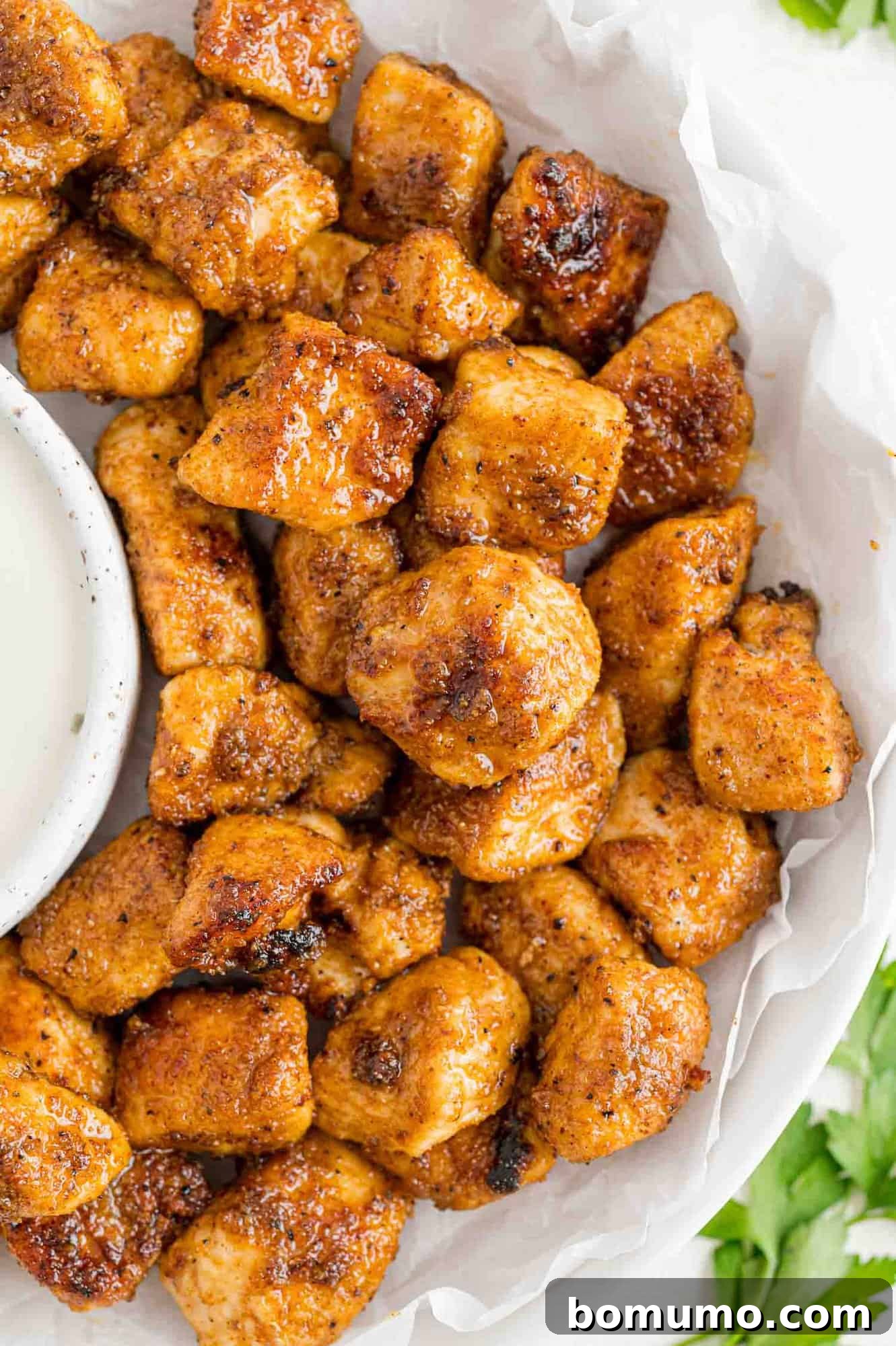 Golden Chicken Bites 2 Crispy, golden chicken bites served on a plate, perfectly paired with a creamy ranch dressing for dipping.