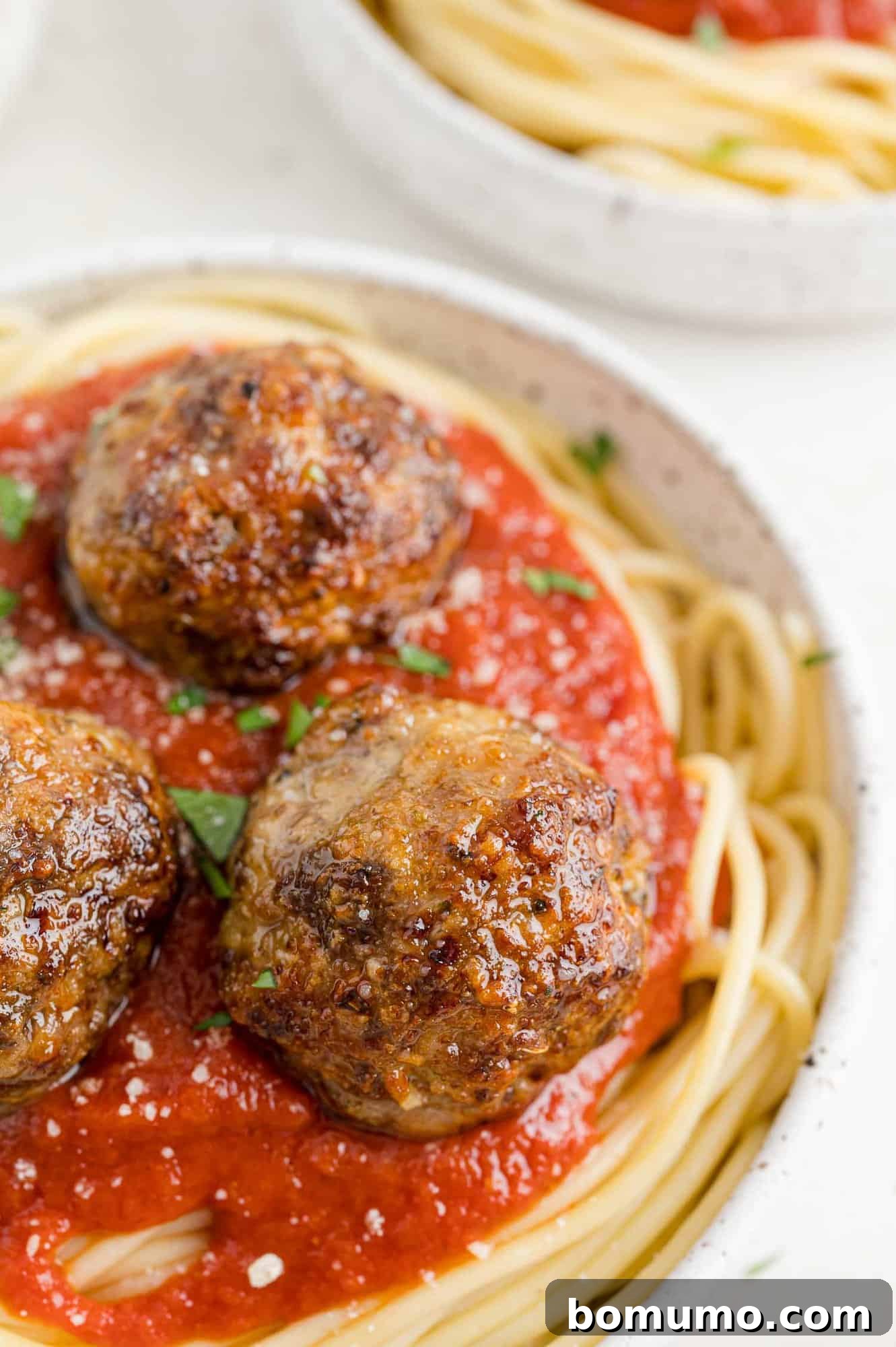 Delicious air fryer meatballs served over a bed of spaghetti with a rich tomato sauce.