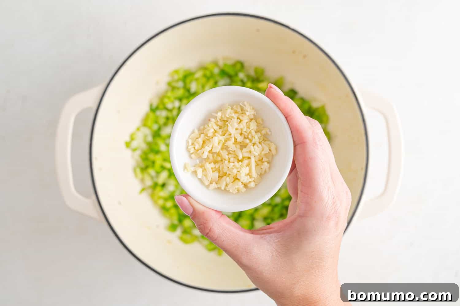 Minced garlic being added to the pan.