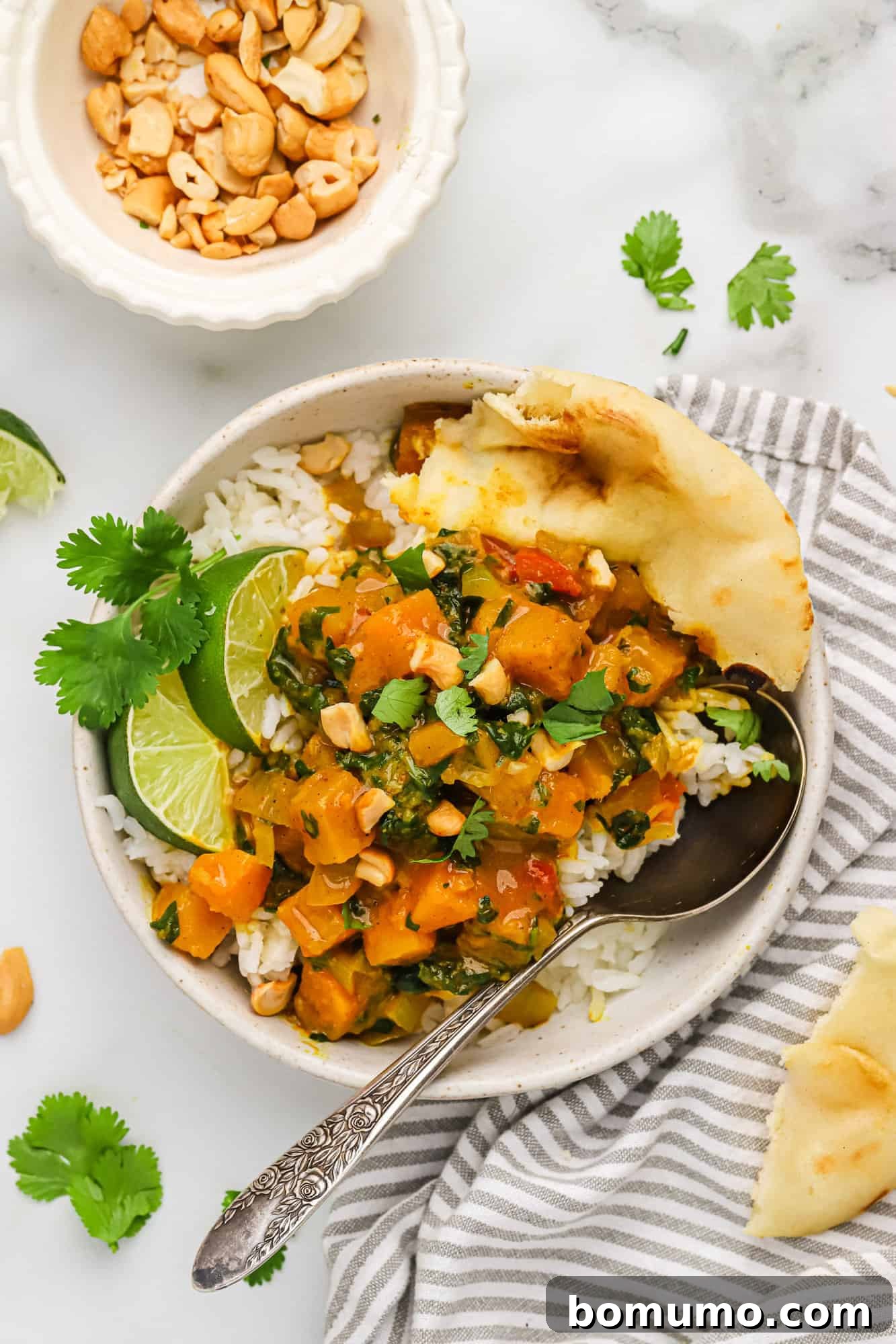 A close-up shot of a creamy and rich butternut squash curry, showcasing tender squash pieces simmered in a vibrant red sauce, ready to be served.