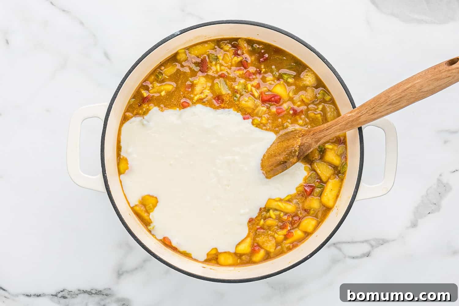 White sauce being added to the Mulligatawny soup in the main pot.