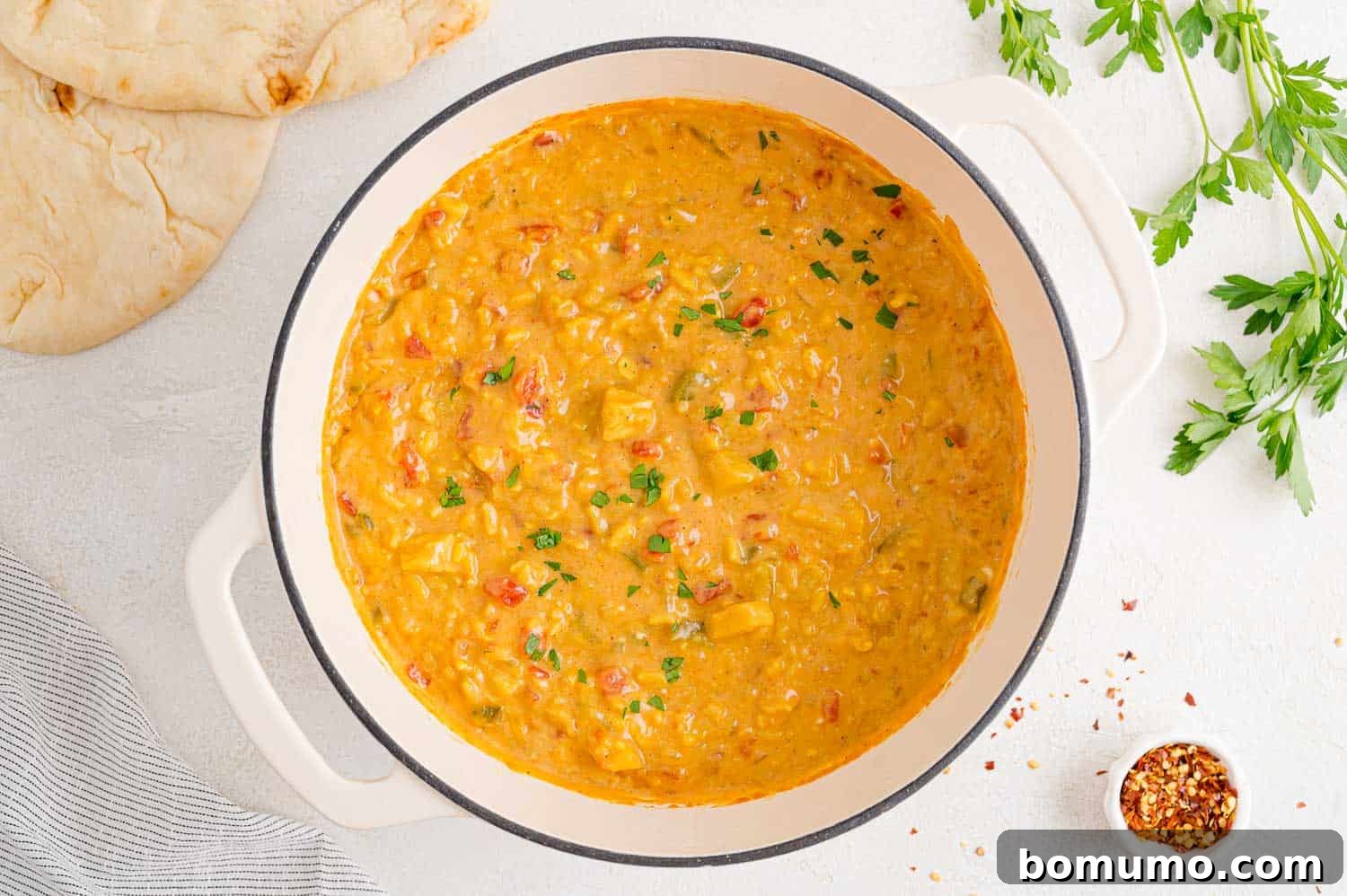 The finished Mulligatawny soup in a large pot, steaming gently.