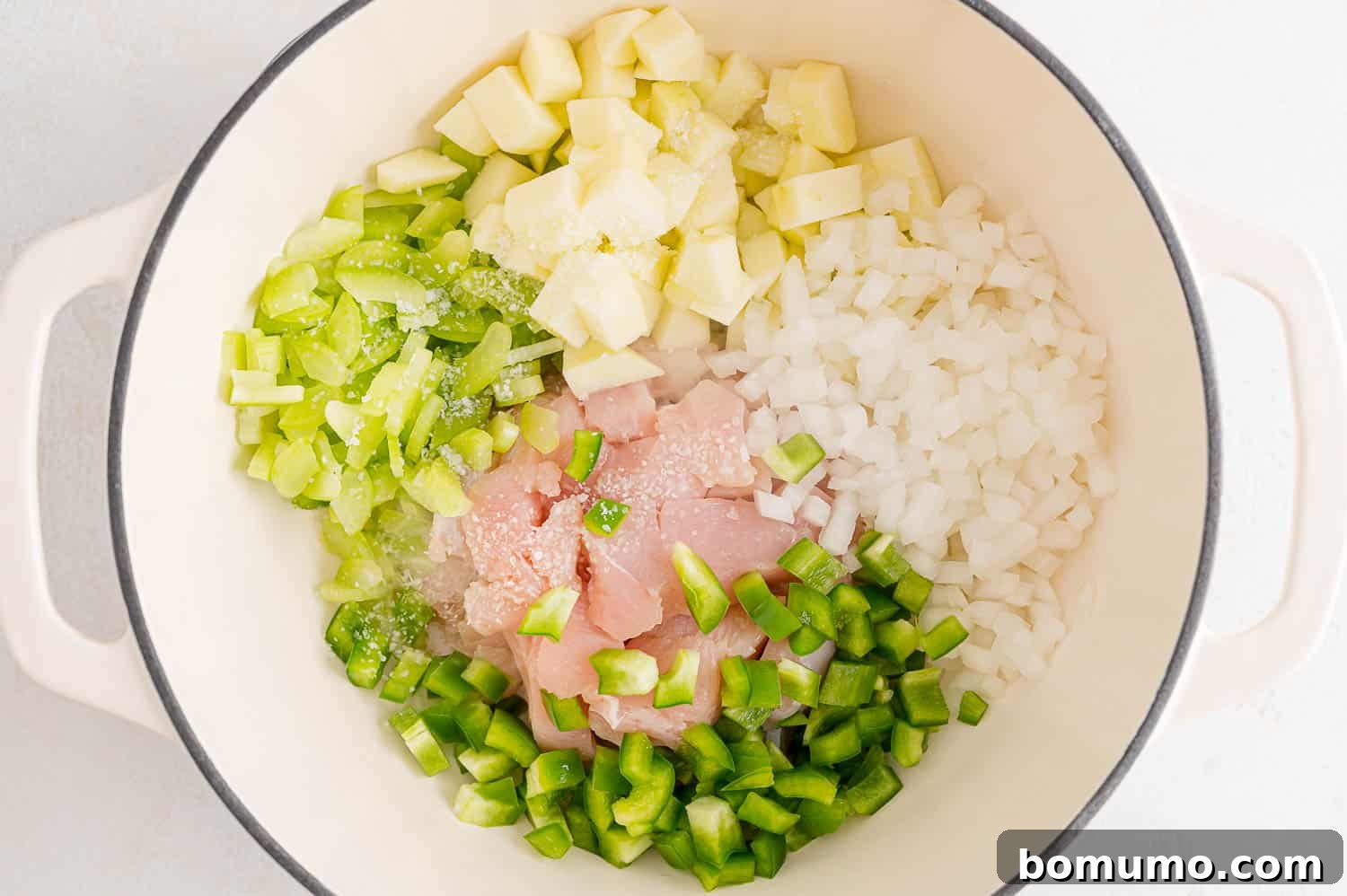 Vegetables and chicken cooking in a large pan, stirring occasionally.