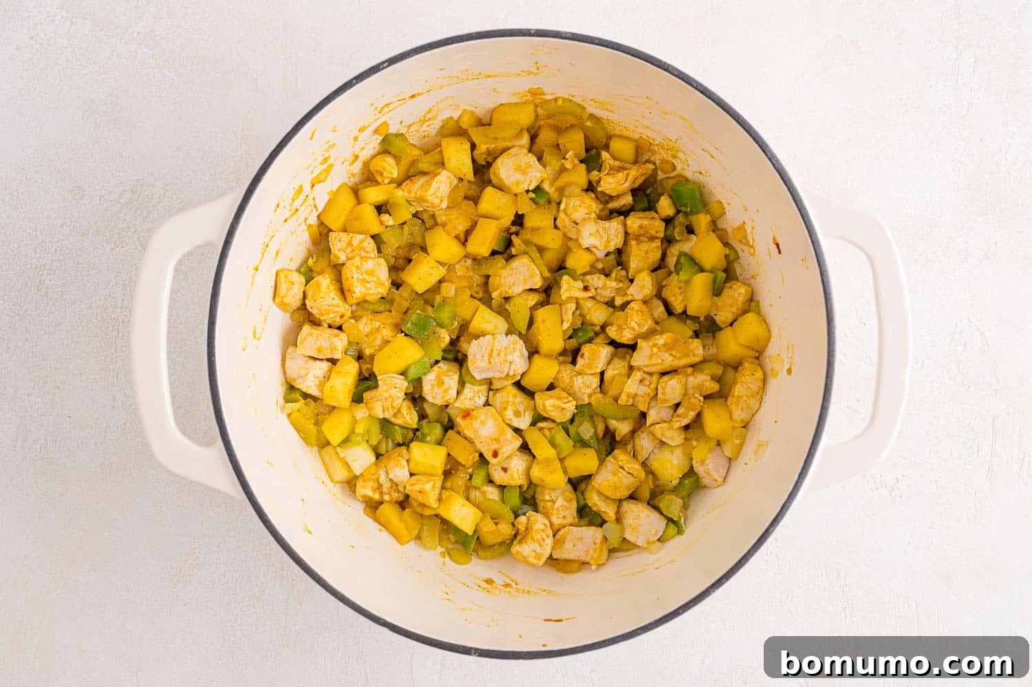 Chicken and vegetables coated with seasoning, ready for the next step.