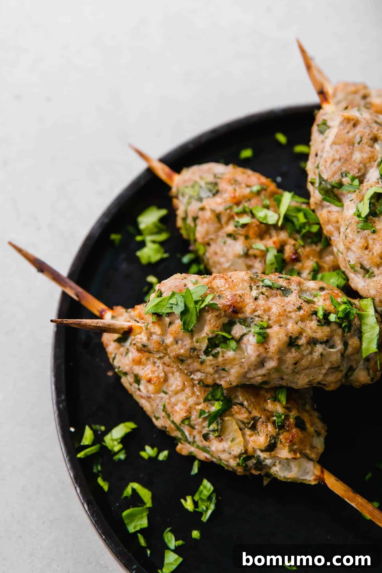 Partial close-up of perfectly cooked chicken kofta, glistening with juices, showcasing its inviting texture.