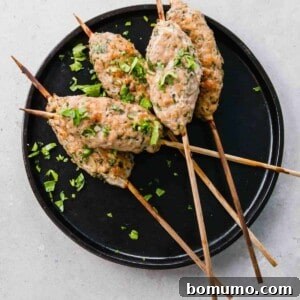 Overhead of prepared chicken kofta on small black plate.