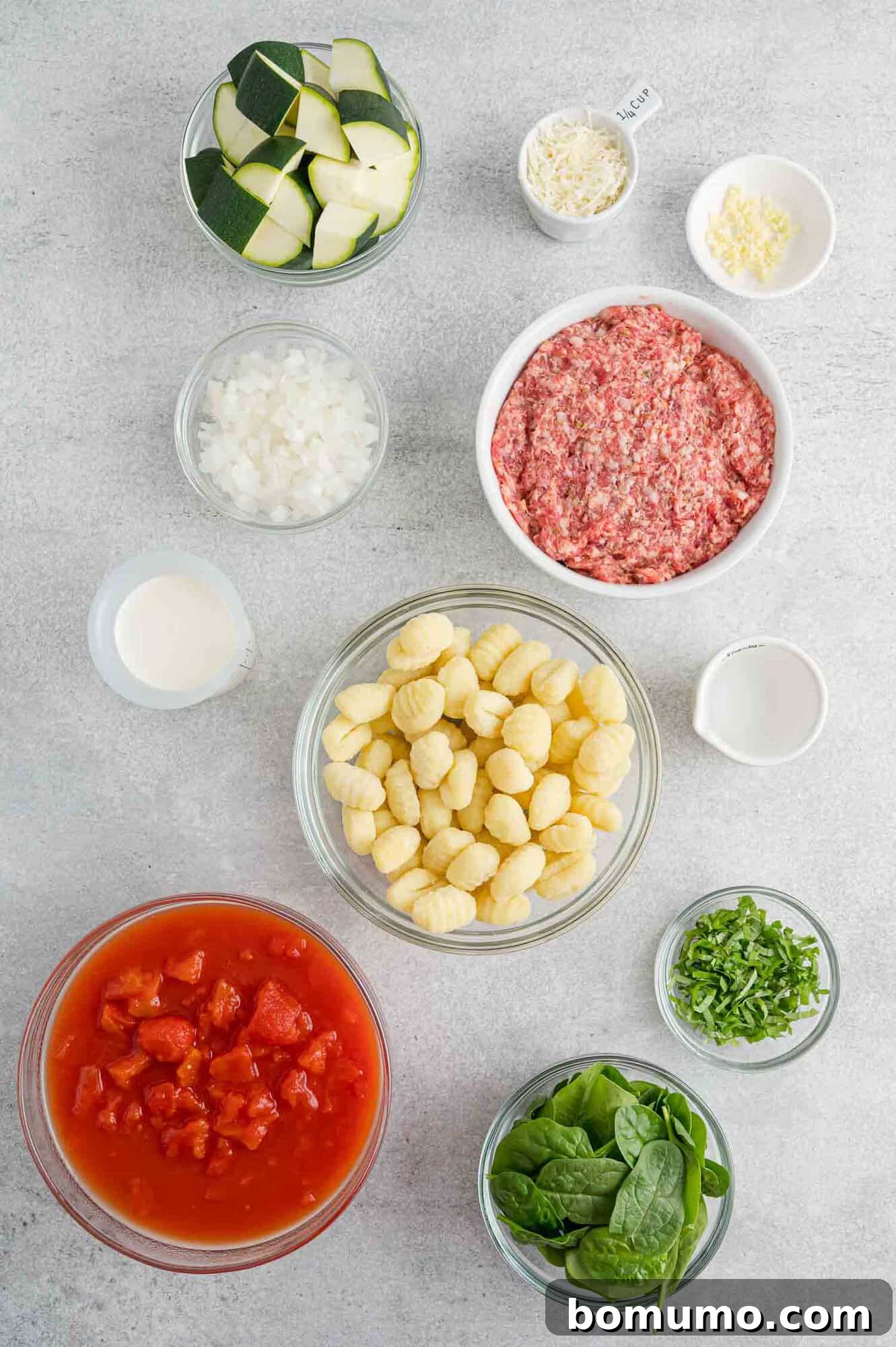 All ingredients laid out on a wooden surface, ready for preparing the creamy one-pan gnocchi recipe.