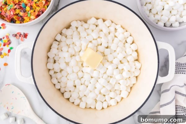 Butter added to a saucepan with mini marshmallows.