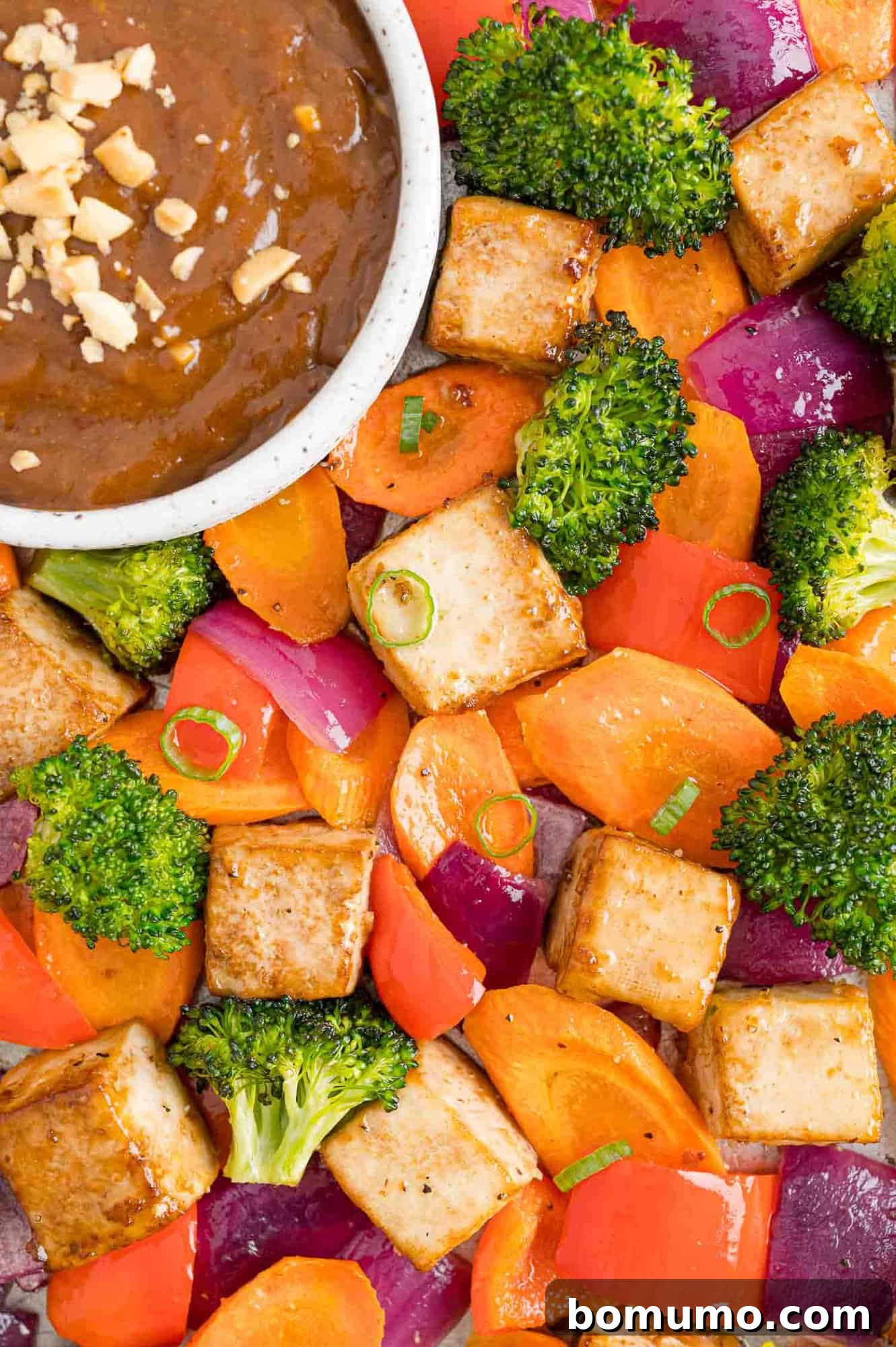 The finished tofu, vegetables, and peanut sauce beautifully arranged on a sheet pan, showcasing the rich flavors and textures.