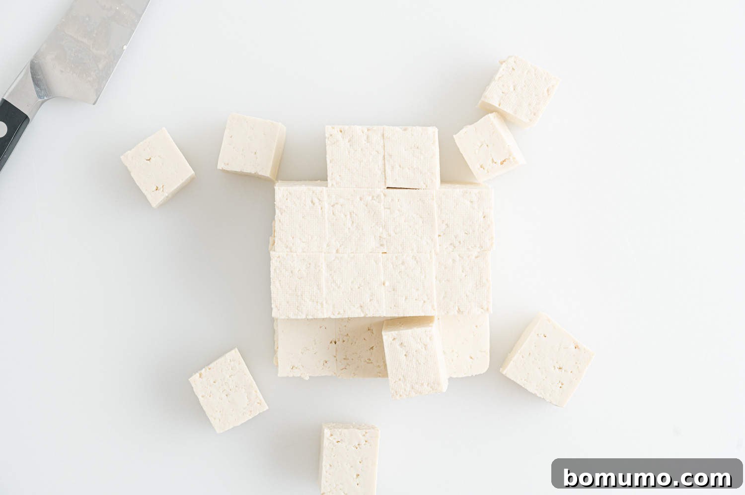 Tofu, expertly cut into uniform cubes, ready for pressing.