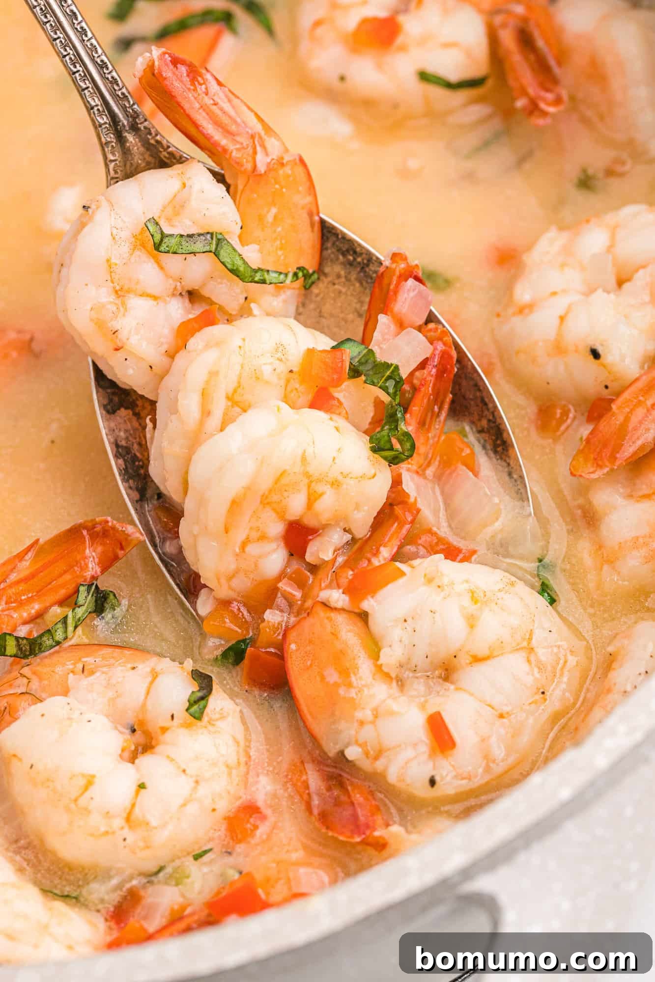 Creamy coconut shrimp on a serving spoon, showcasing the rich sauce and succulent shrimp.