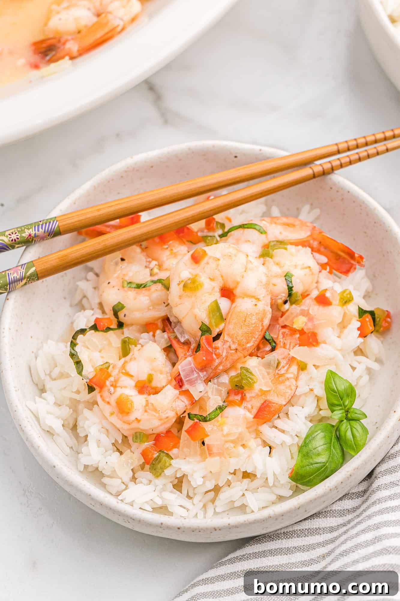 Creamy coconut shrimp beautifully served over a bed of white rice, garnished for freshness.