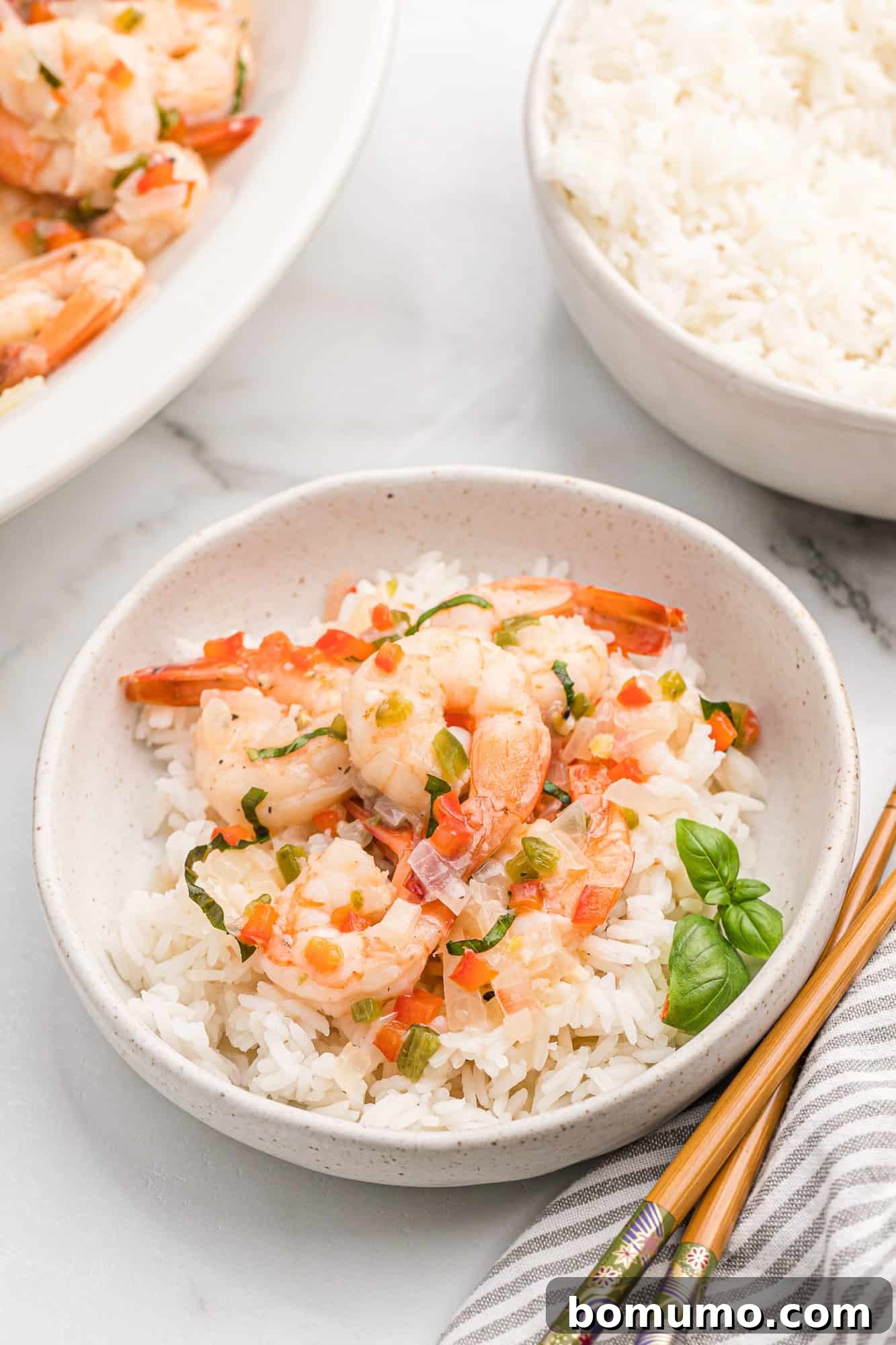 Creamy coconut shrimp served in a bowl with fluffy rice and fresh basil leaves, ready to be enjoyed.