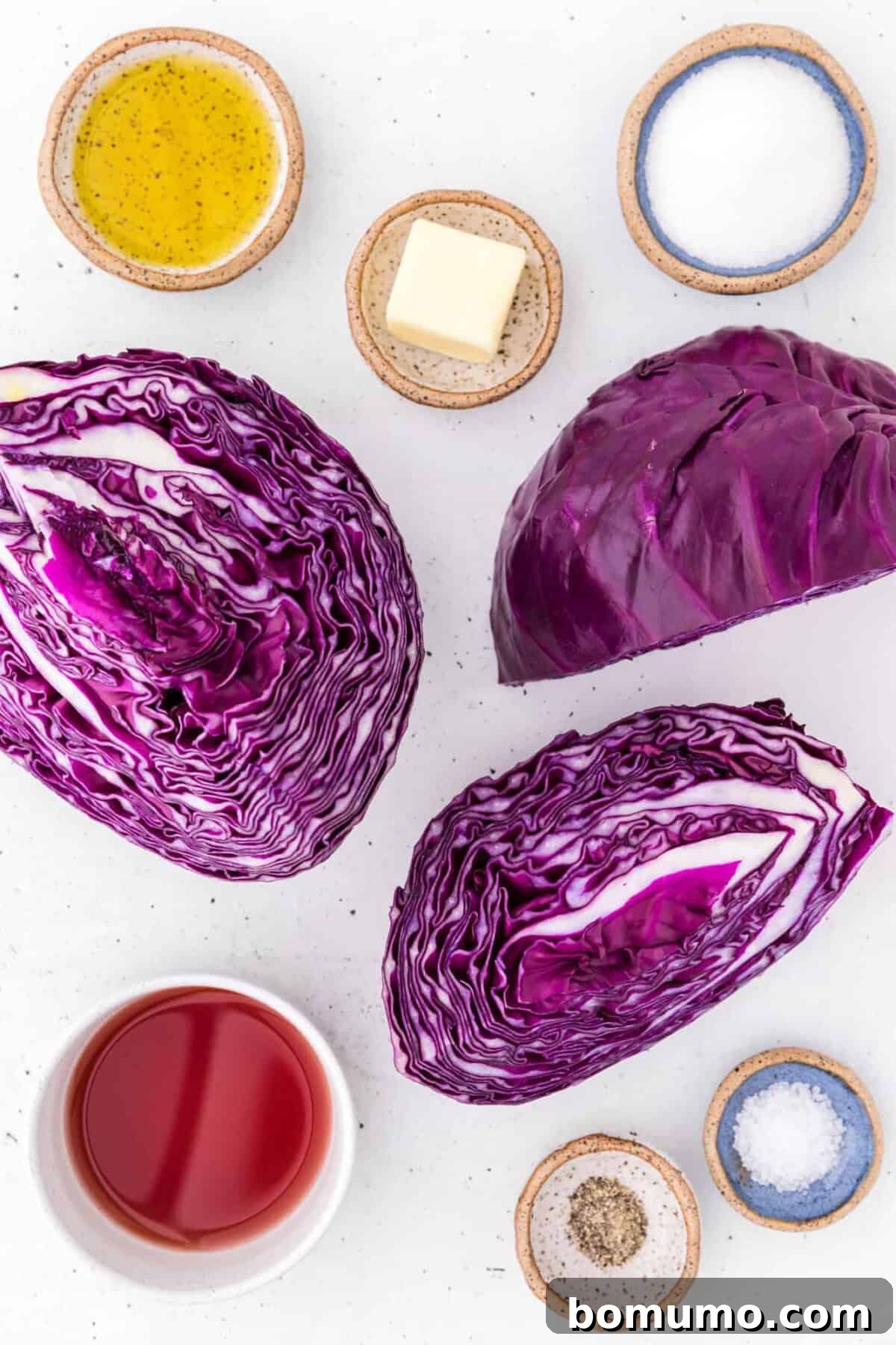 Fresh red cabbage, alongside butter, olive oil, and vinegar, laid out as ingredients for the recipe.