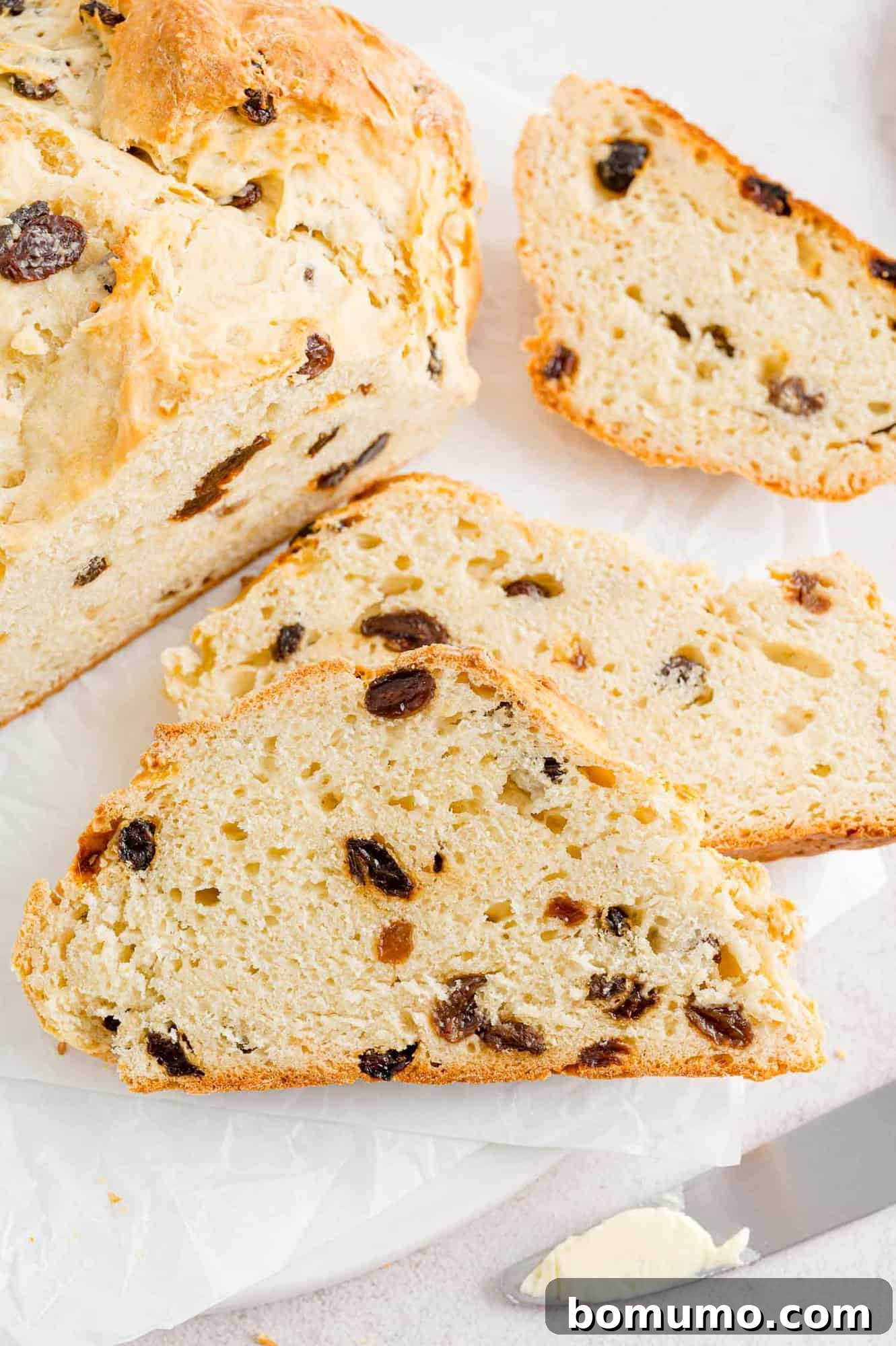 Perfectly sliced Irish soda bread with visible raisins.