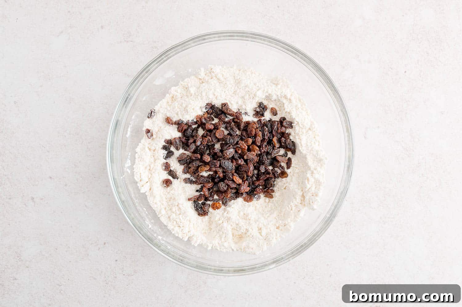 Raisins being added to the flour and butter mixture.