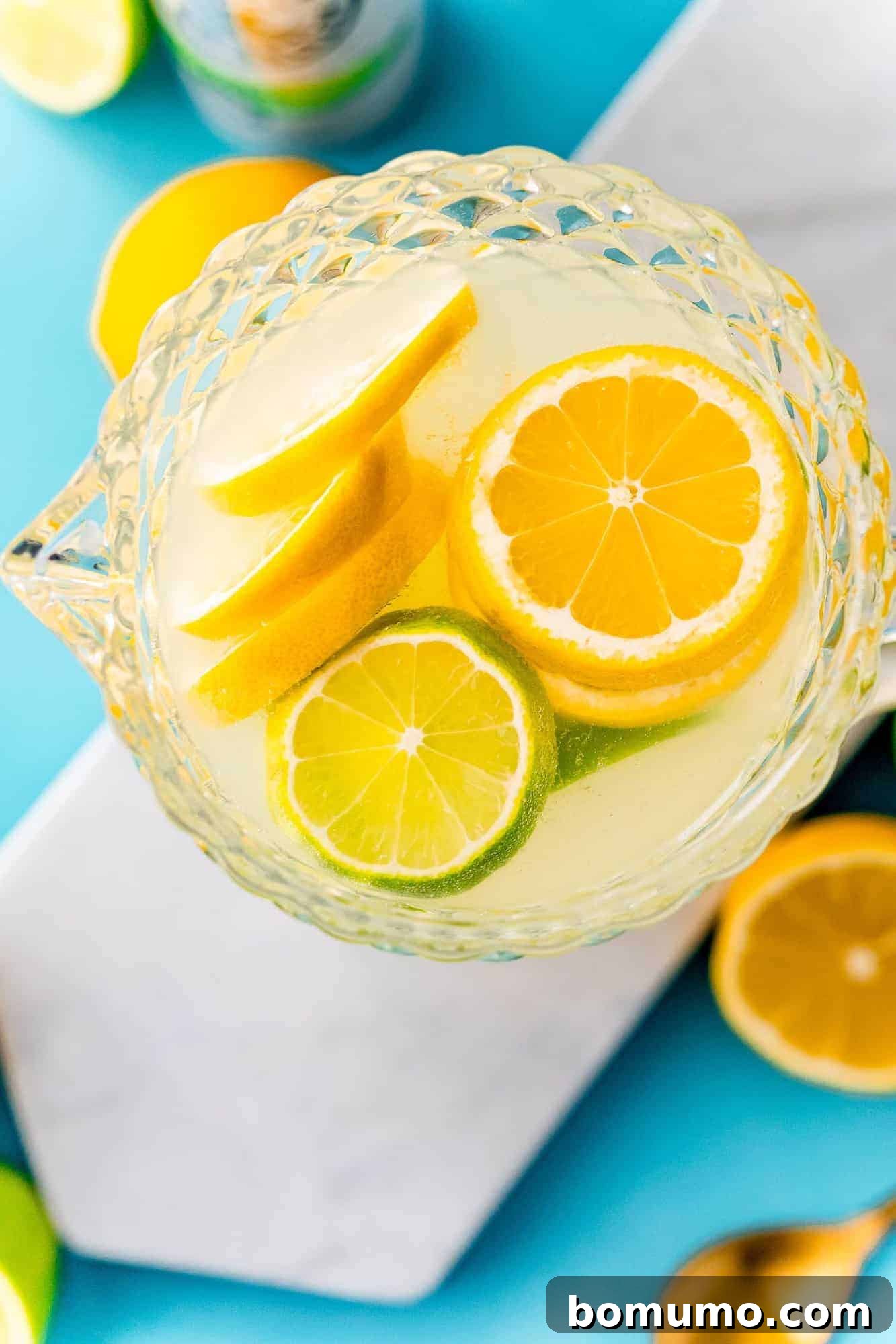 Overhead view of a pitcher filled with spiked lemonade, garnished with fresh citrus slices, ready to be served.
