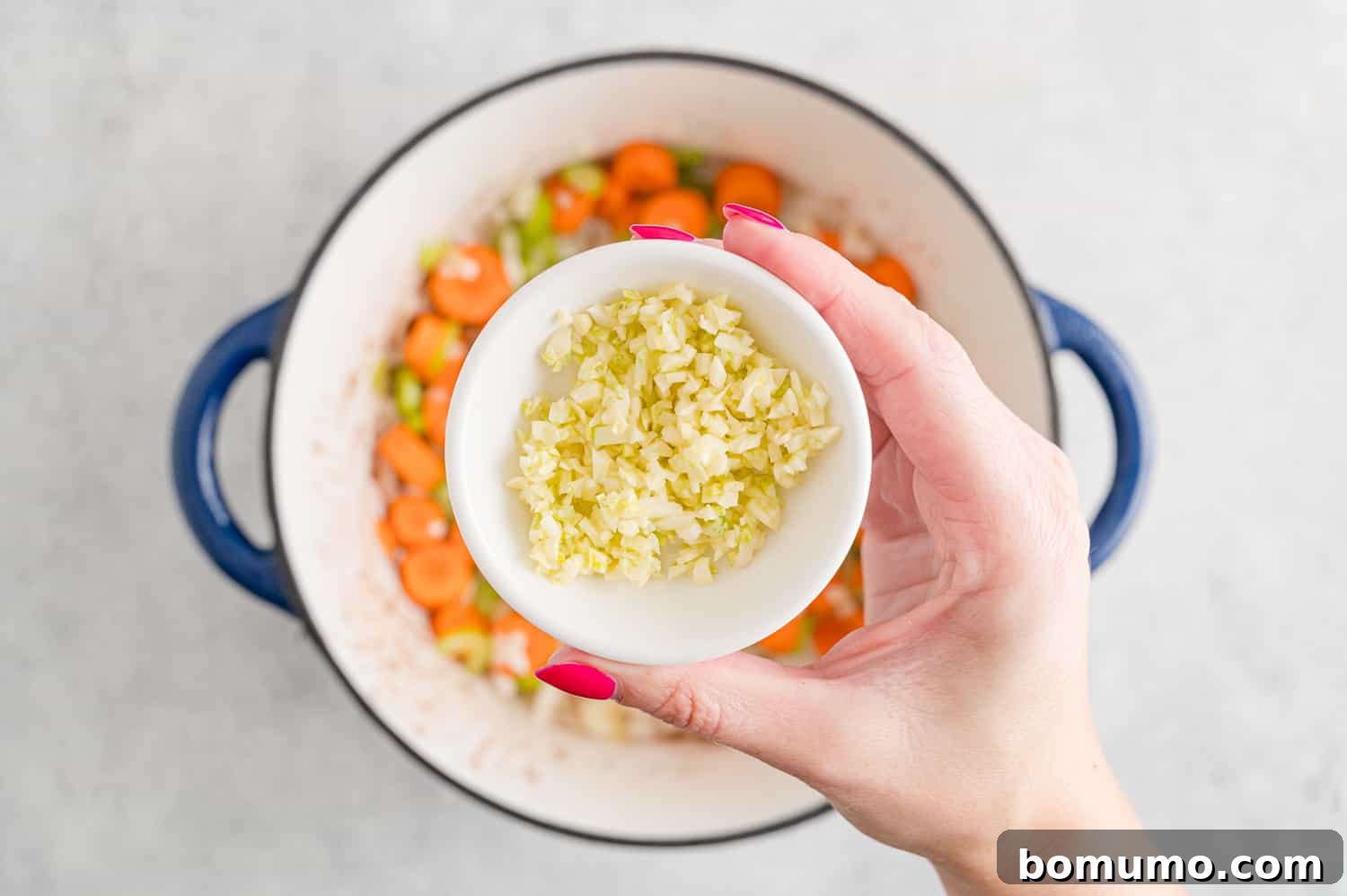 Garlic being added to pan.