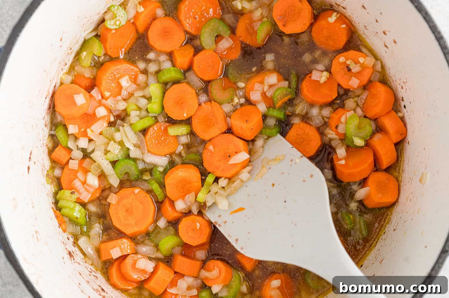Pan being deglazed with broth.