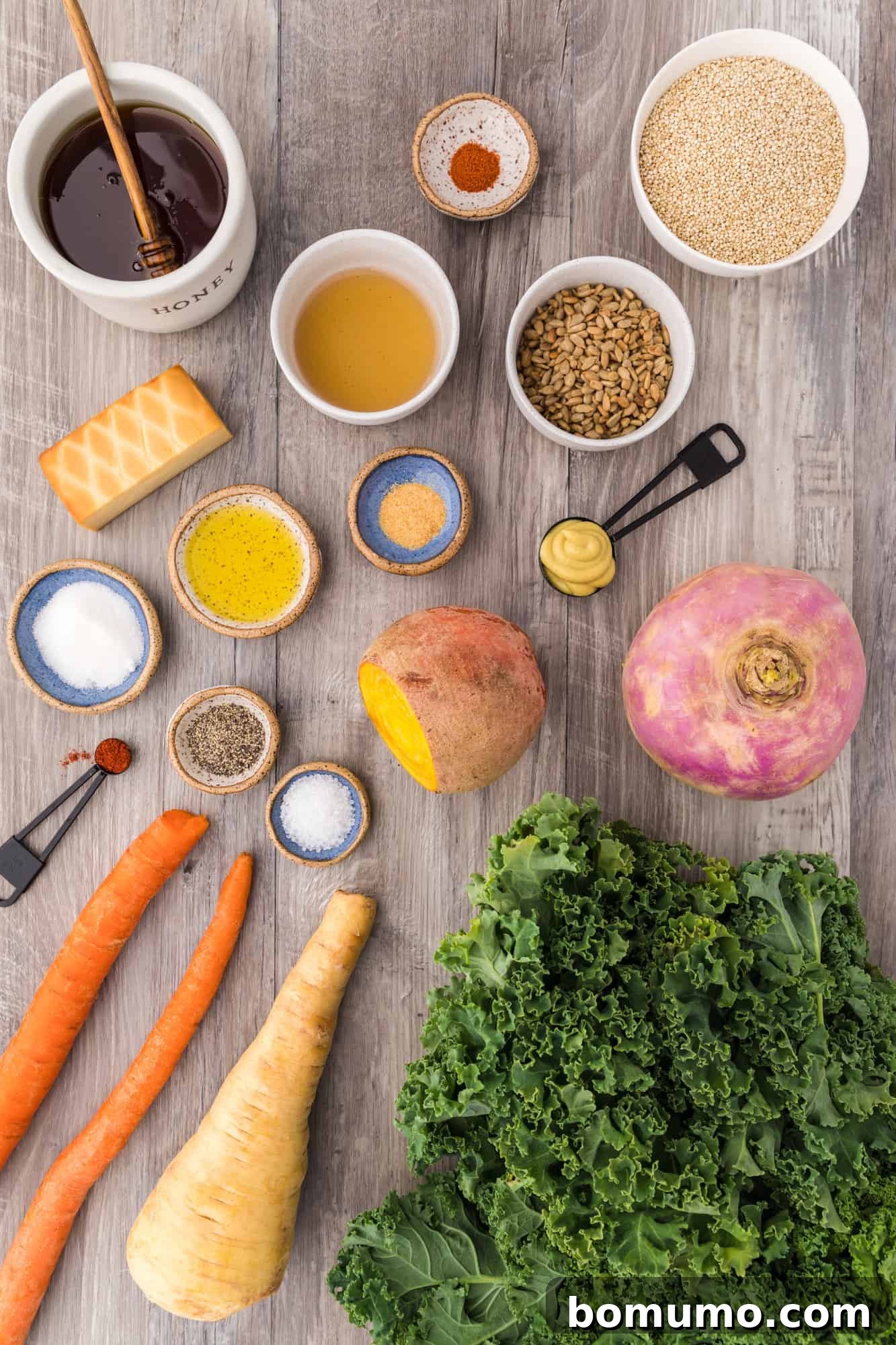 A curated display of all the fresh ingredients needed to prepare the warm kale salad, including kale, carrots, beets, and quinoa.