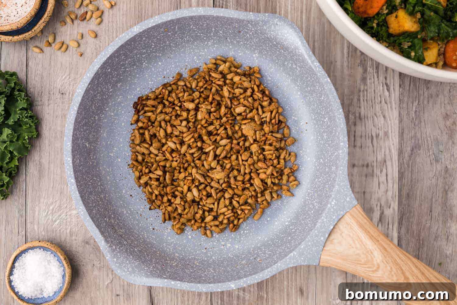 Perfectly candied sunflower seeds cooling in a frying pan after being cooked.