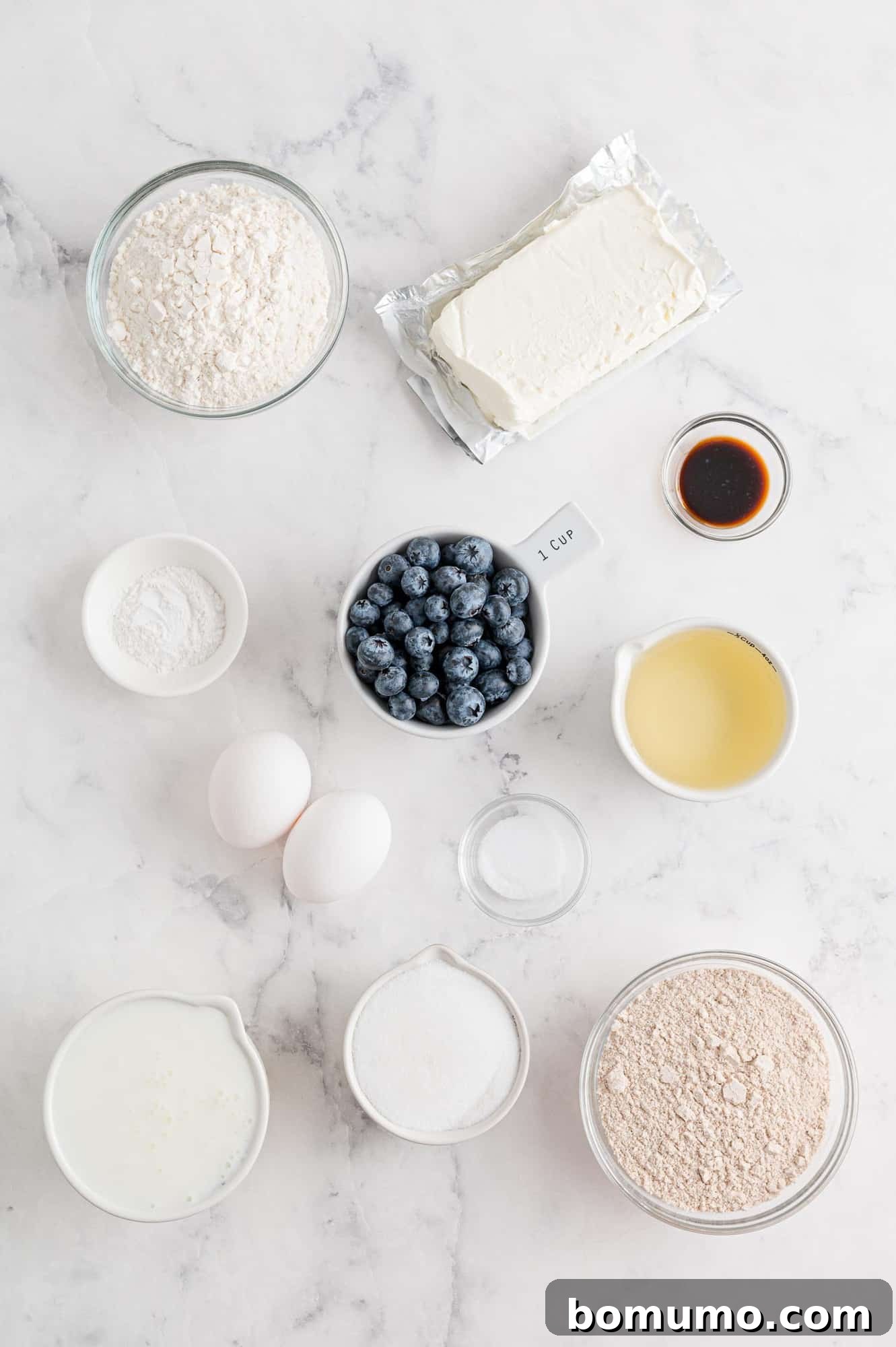 All the necessary ingredients for the blueberry cream cheese muffins, neatly organized in separate containers, ready for baking.