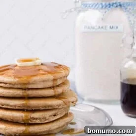 Image of a stack of pancakes with homemade pancake mix in the background.