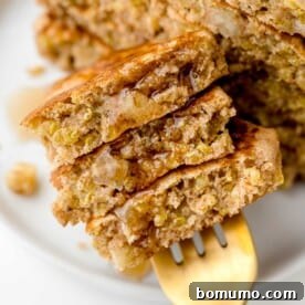 Apple quinoa pancakes on a fork with syrup.