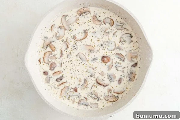 Creamy marsala sauce with tender mushrooms simmering in a skillet, perfectly thickened.