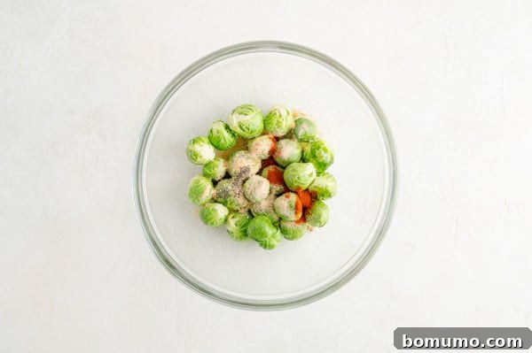 These are the best grilled Brussels sprouts! Cooked until golden and tossed in a combination of zesty lemon, parmesan, and fresh herbs. Seasonings added to microwaved Brussels sprouts in a glass bowl.