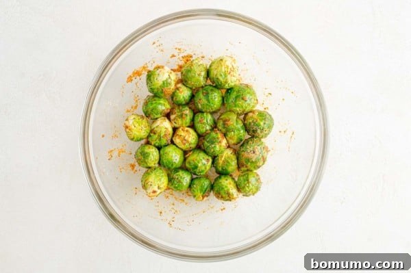 These are the best grilled Brussels sprouts! Cooked until golden and tossed in a combination of zesty lemon, parmesan, and fresh herbs. Seasoned microwaved Brussels sprouts in a glass bowl.