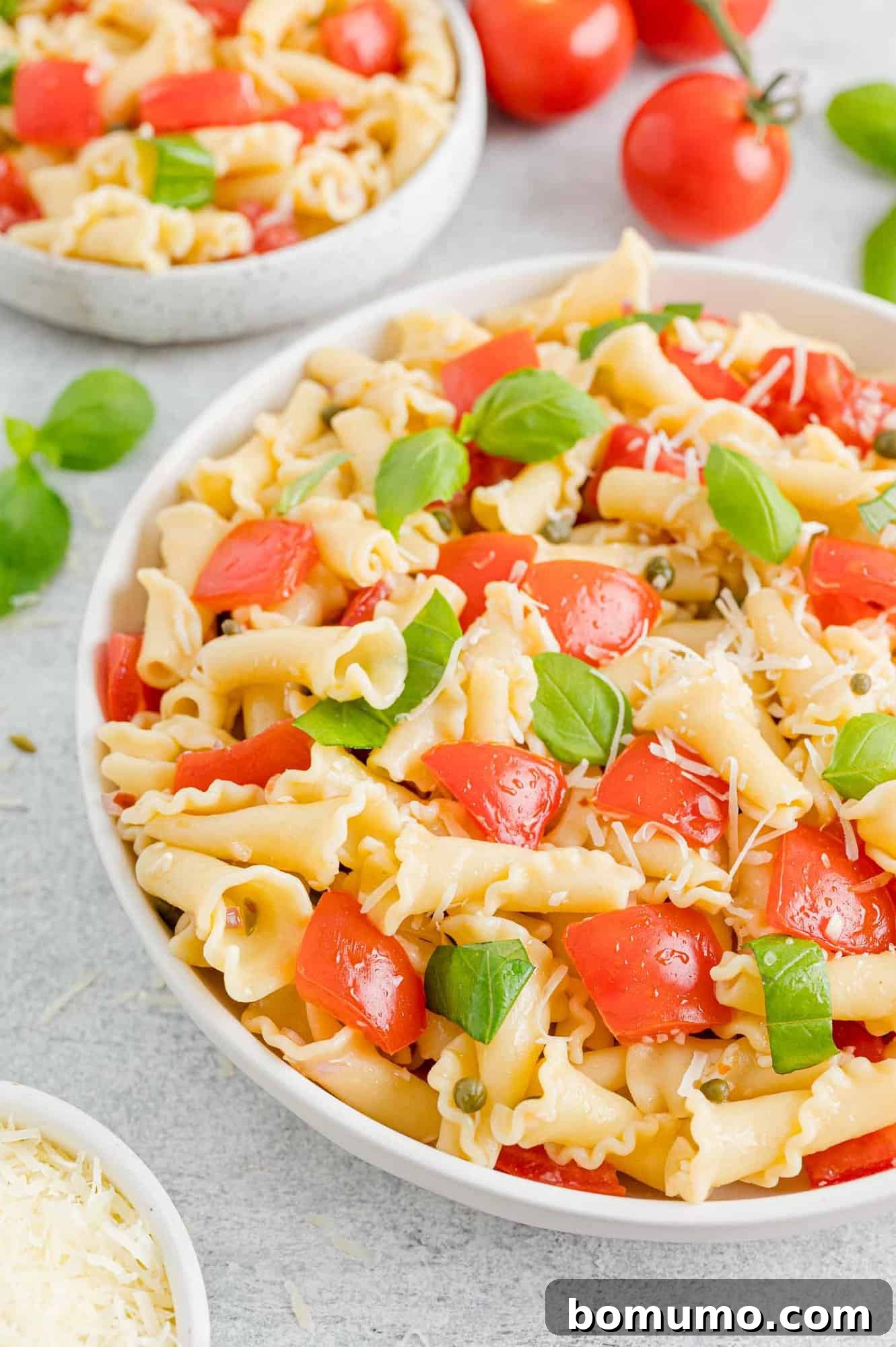 A large serving bowl of fresh tomato pasta.